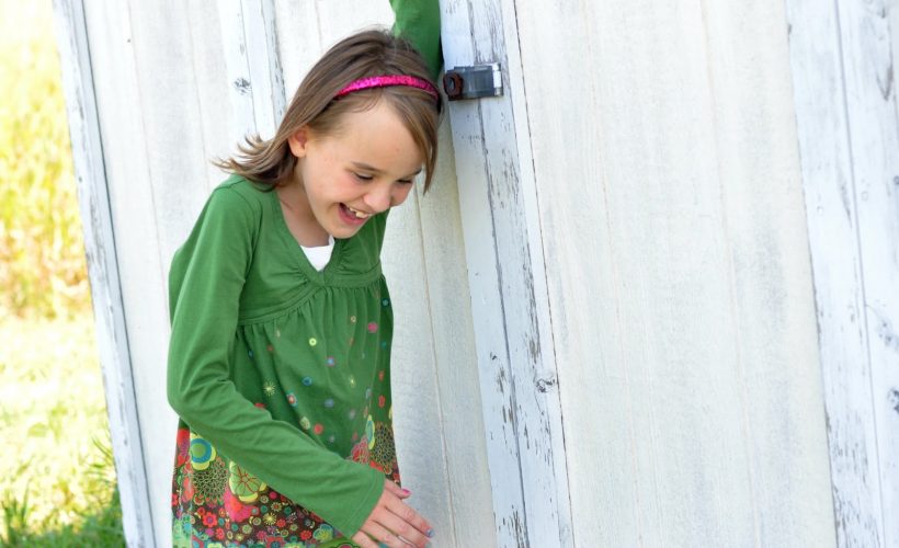 Girl laughing by shed by Katie M.