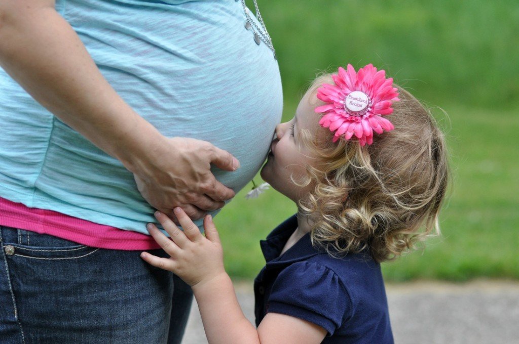 Daughter kissing Mom's pregnant belly by Katie M. Reid Photography